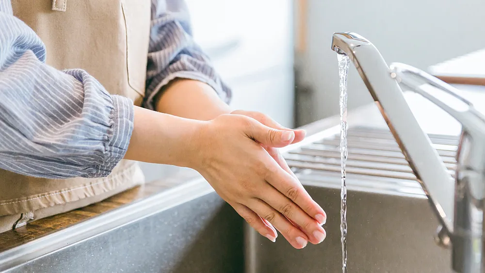 キッチンで手を洗う女性