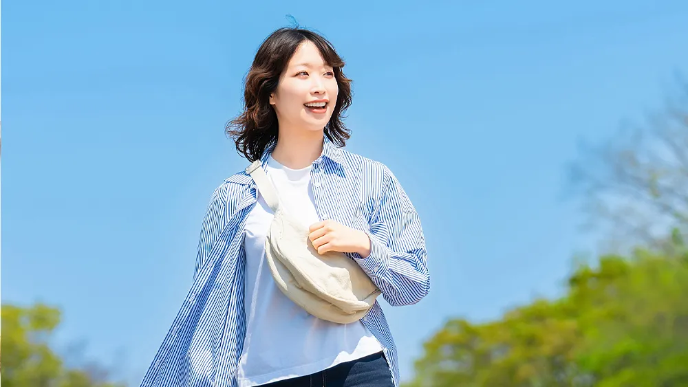 日差しの中を歩く女性