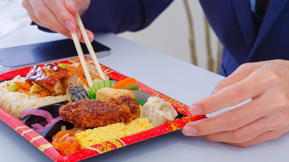 コンビニ弁当を食べる人