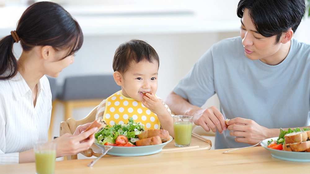 幼児と両親の食事風景