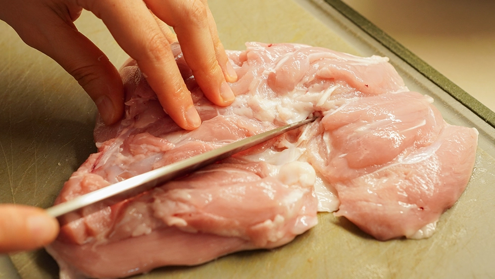 鶏肉を調理する手