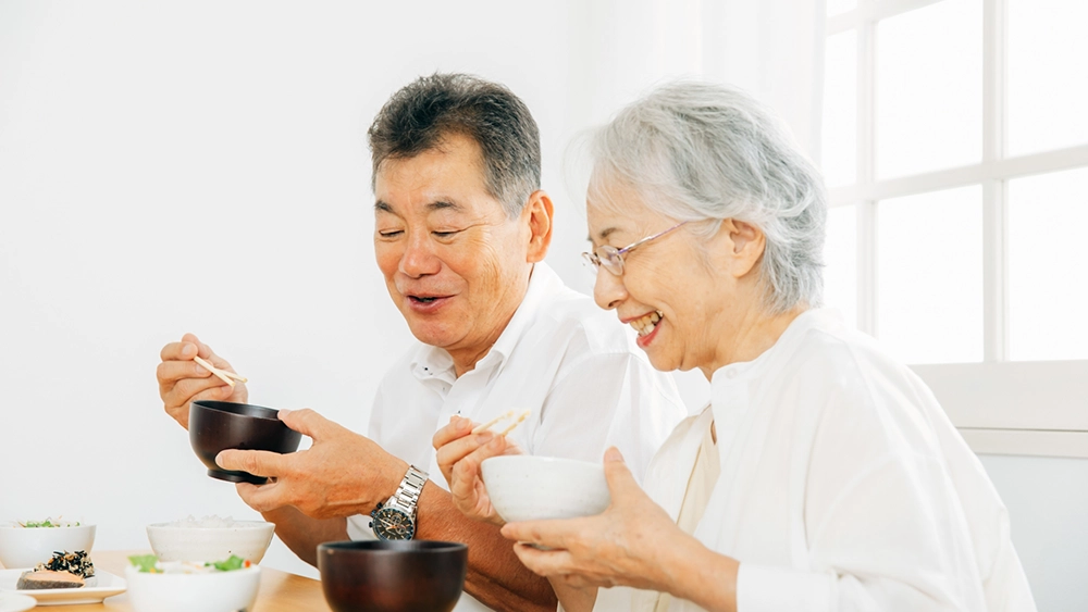 笑顔で食事をする高齢者夫婦