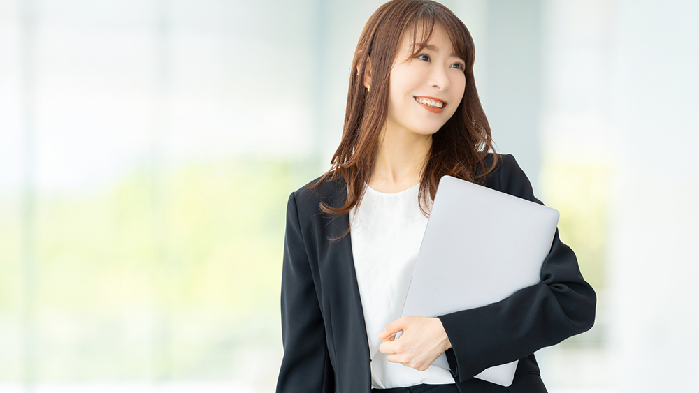 パソコンを持つ笑顔の女性