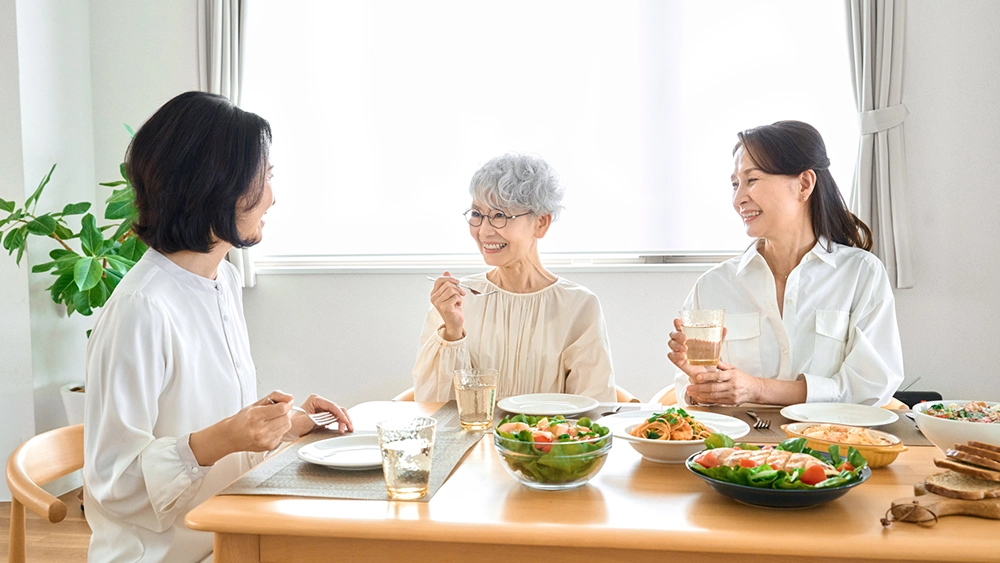 家族と笑顔で食事をする高齢者